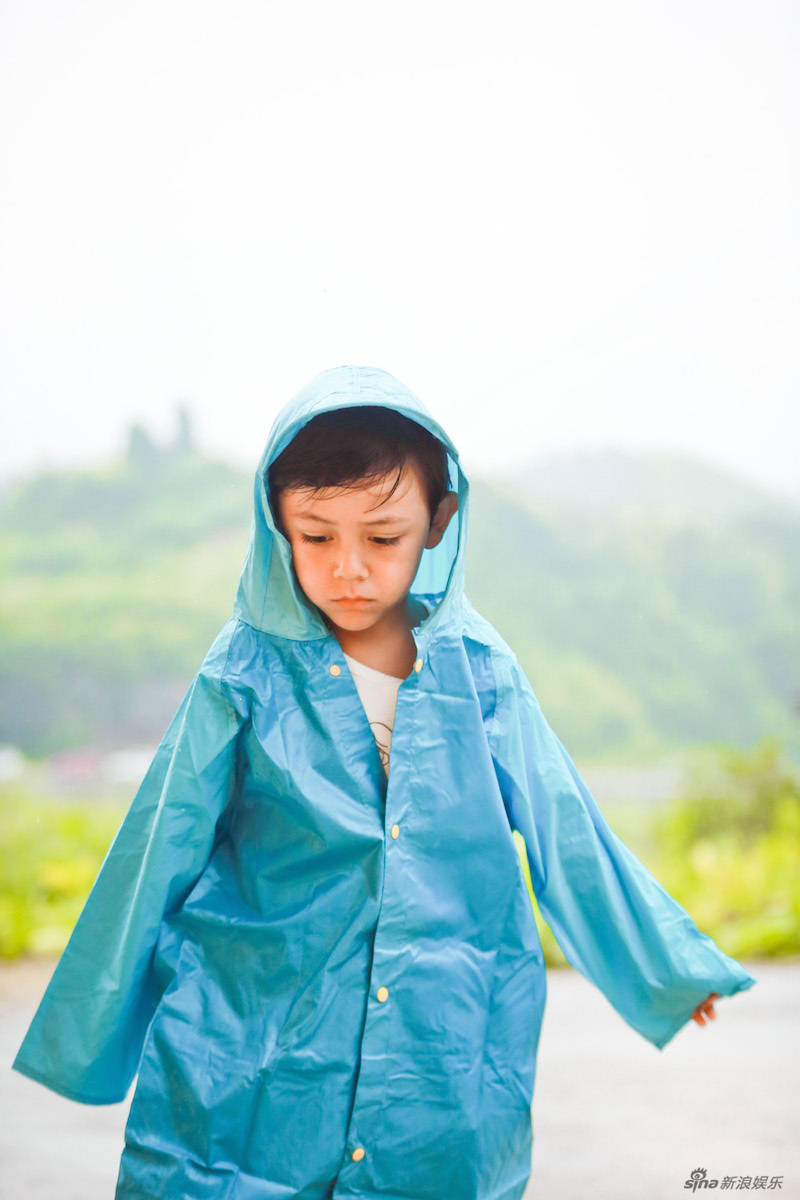 混血小萌娃诺一一组雨中写真曝光,照片中诺一身穿蓝色雨衣,站在室外