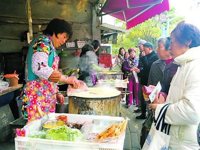 煎饼果子摊前,居民排队买早餐.黄尖尖摄