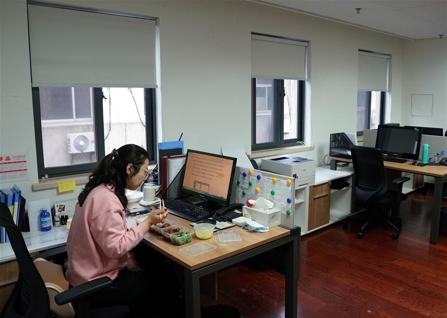 2月11日,在上海静安置业集团的办公室,办公人员将午餐领回办公室用餐.